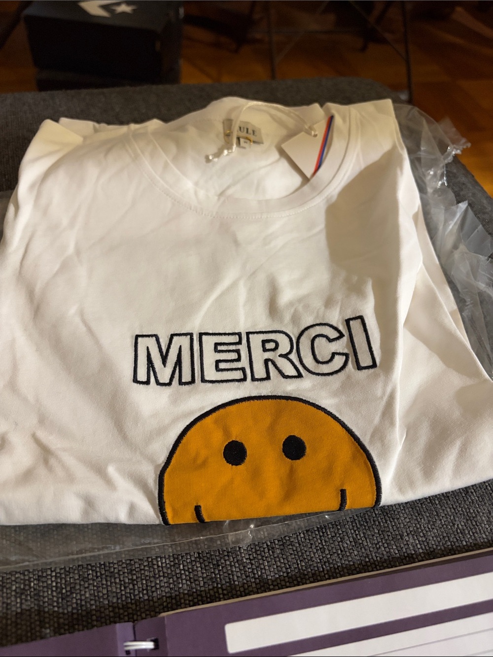 Women’s White "MERCI" Graphic Tee with Yellow Smiley
